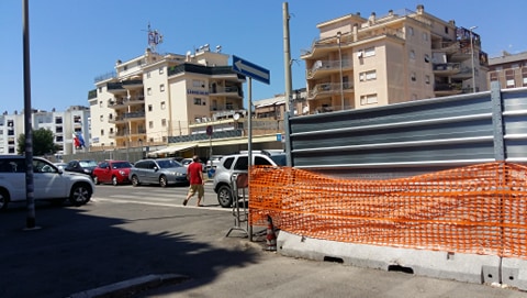Una delel voragini che chiudono via Zambrini: sullo sfondo la caserma dei Carabinieri