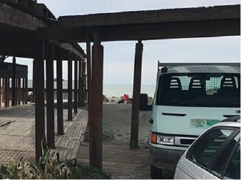 Operai e mezzi al lavoro per la rimozione del chiosco sulla spiaggia libera ex Amanusa di Ostia